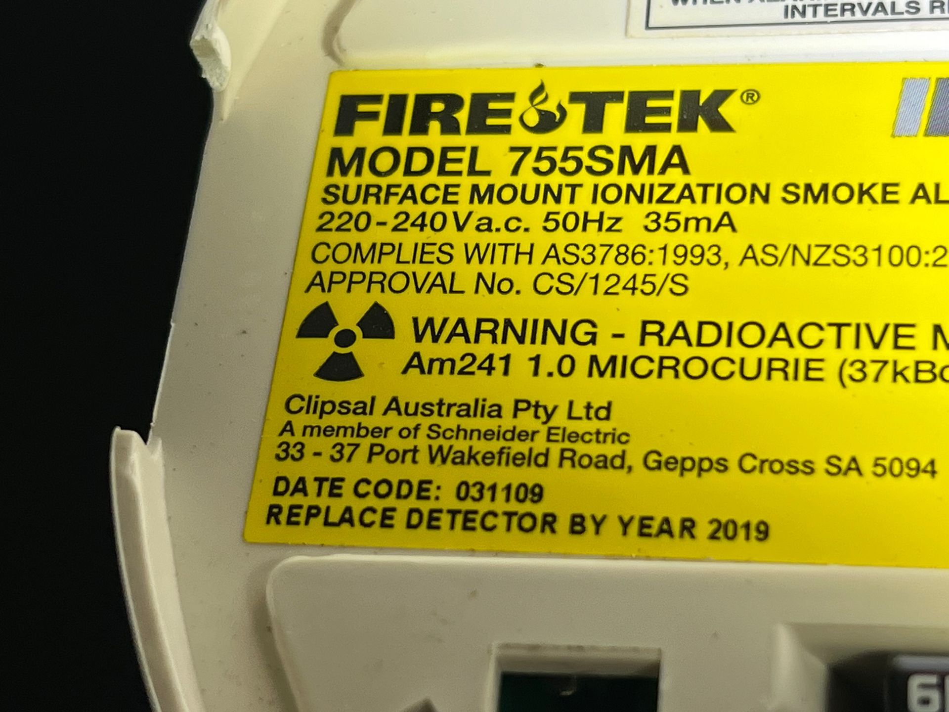 A yellow label on a FireTek smoke alarm listing model 755SMA, radioactive Americium-241 content, and a 2019 expiry date.