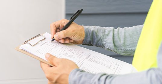 Building inspector documenting site findings.