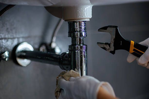 Chrome faucet with water drop about to fall.