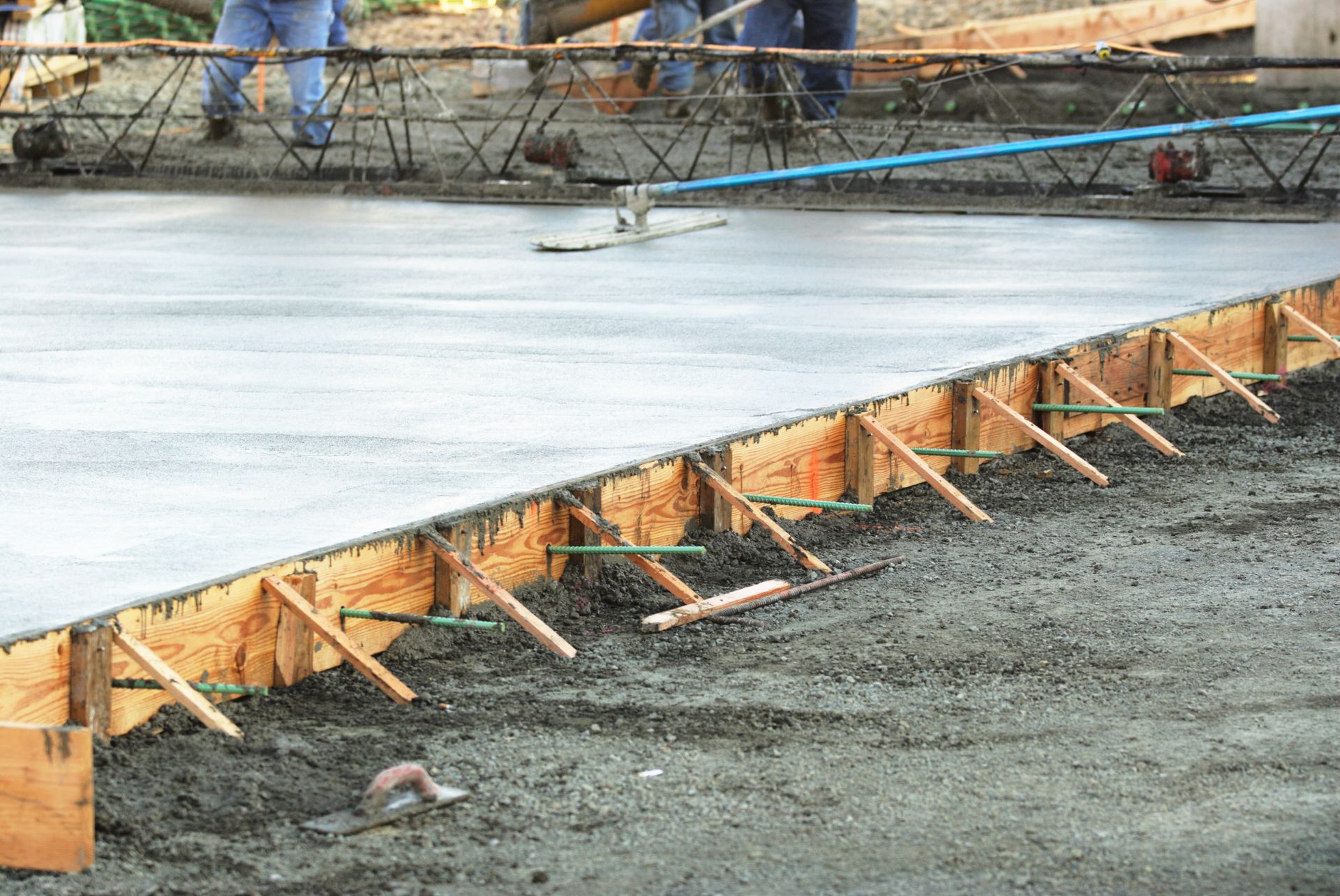 A concrete floor is being poured on a construction site.