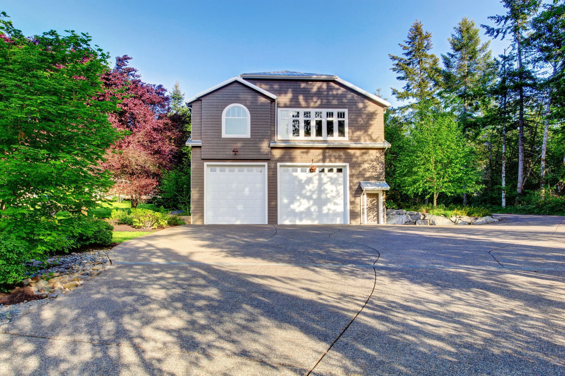 A large house with two garages and a driveway surrounded by trees. — Cumming, GA — Curb Appeal Systems