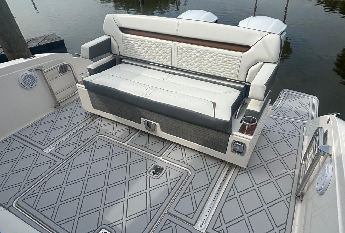 Interior view of a recreational boat cabin with cream and charcoal upholstered seating.