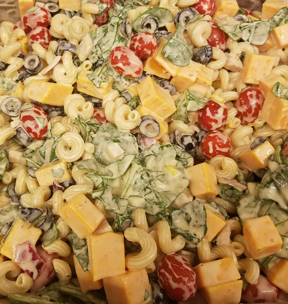 A salad with macaroni cheese olives and other vegetables