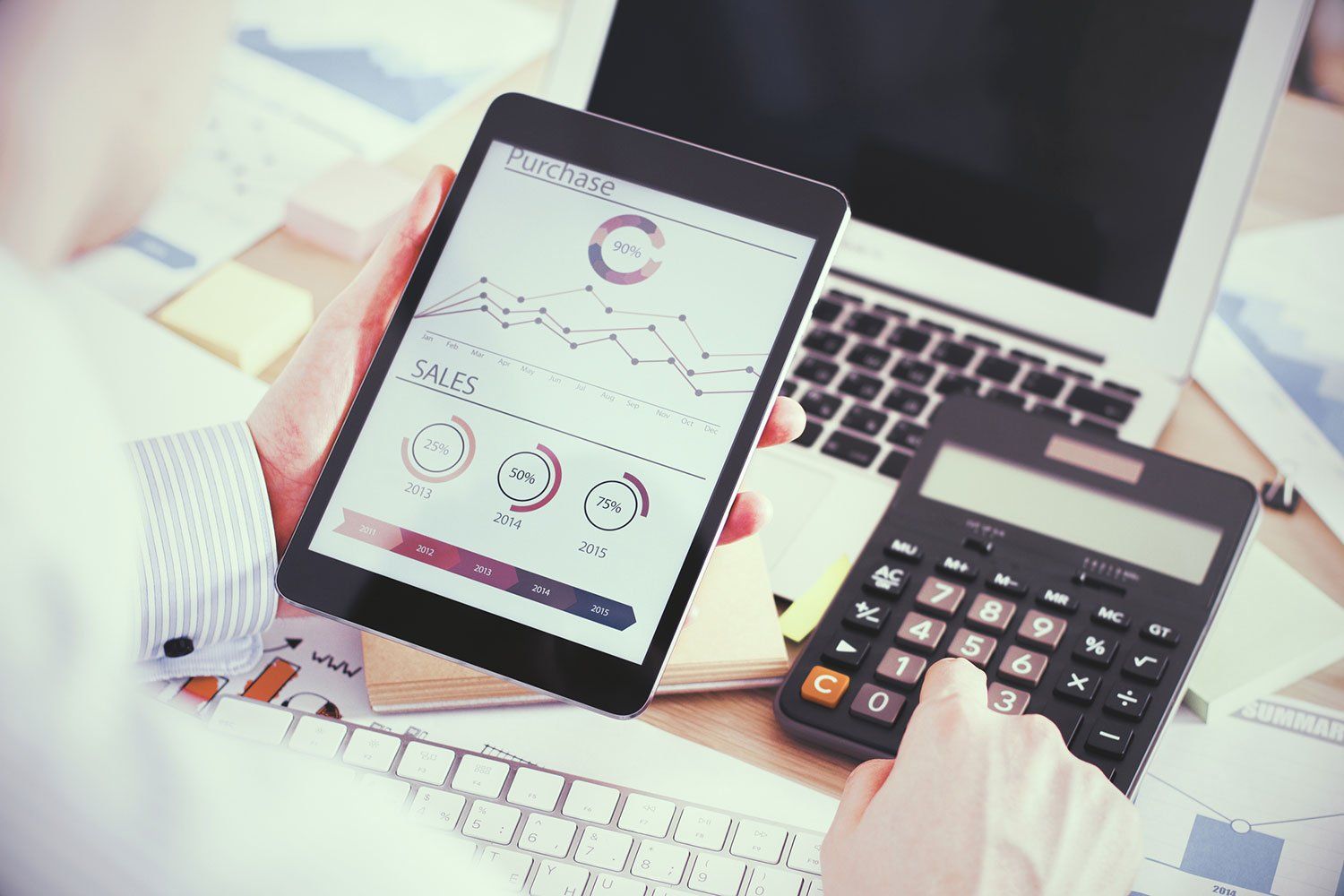 Man Using Tablet and Calculator — Augusta, GA — Jones, Jones, Davis, & Associates, CPA, PC