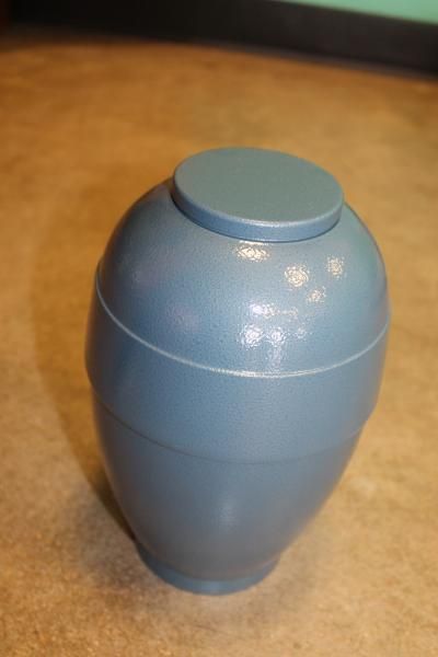 Blue ceramic urn on a tabletop with a rounded lid