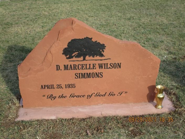 Orange gravestone in grass for D. Marcelle Wilson Simmons, dated April 25, 1935, with a gold vase holder.