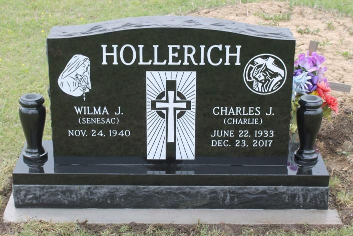 Black granite Hollerich headstone with white lettering and cross emblems in a grassy cemetery.