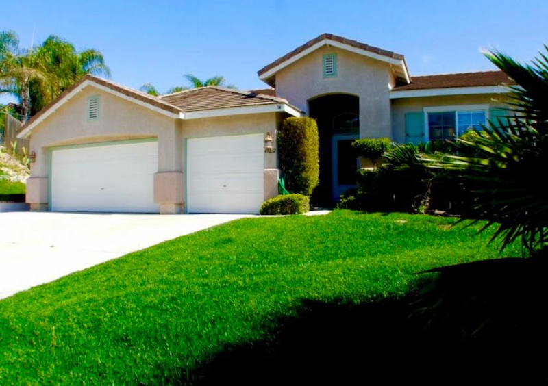 A House with Two Garage Doors and A Lush Green Lawn