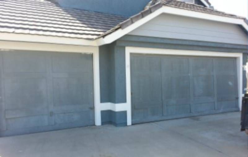 A Gray House with Two Garage Doors and A White Trim