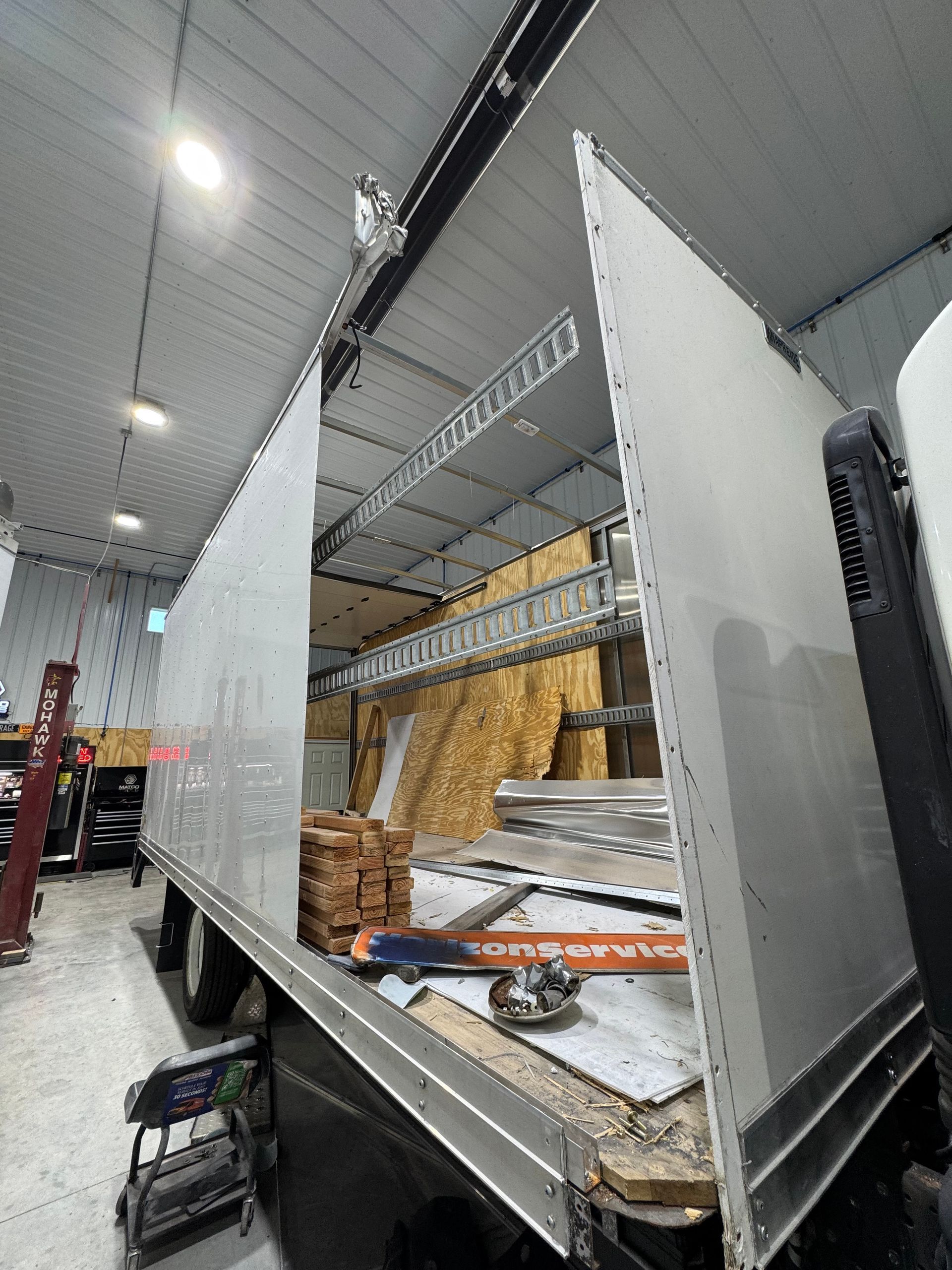 Interior of B&G Auto Body facility showing large truck repair in progress