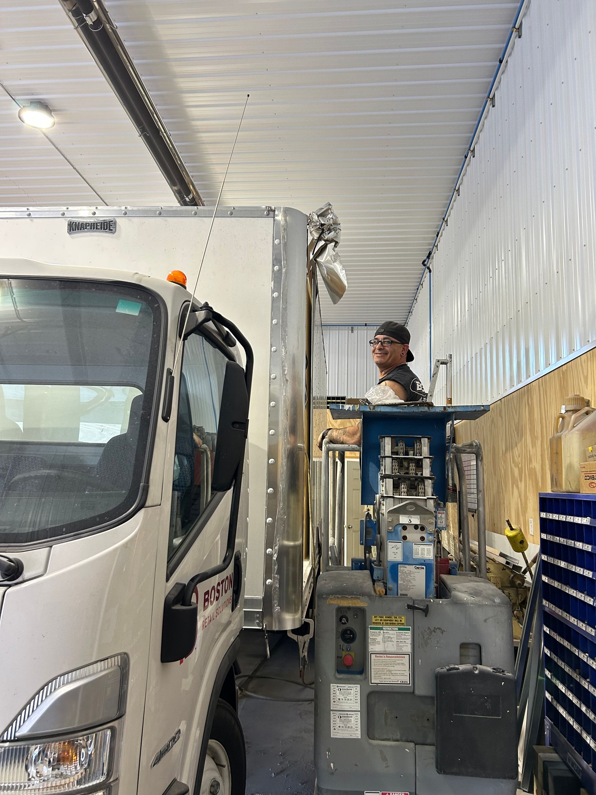 Technician working on heavy-duty truck repair inside B&G Auto Body shop