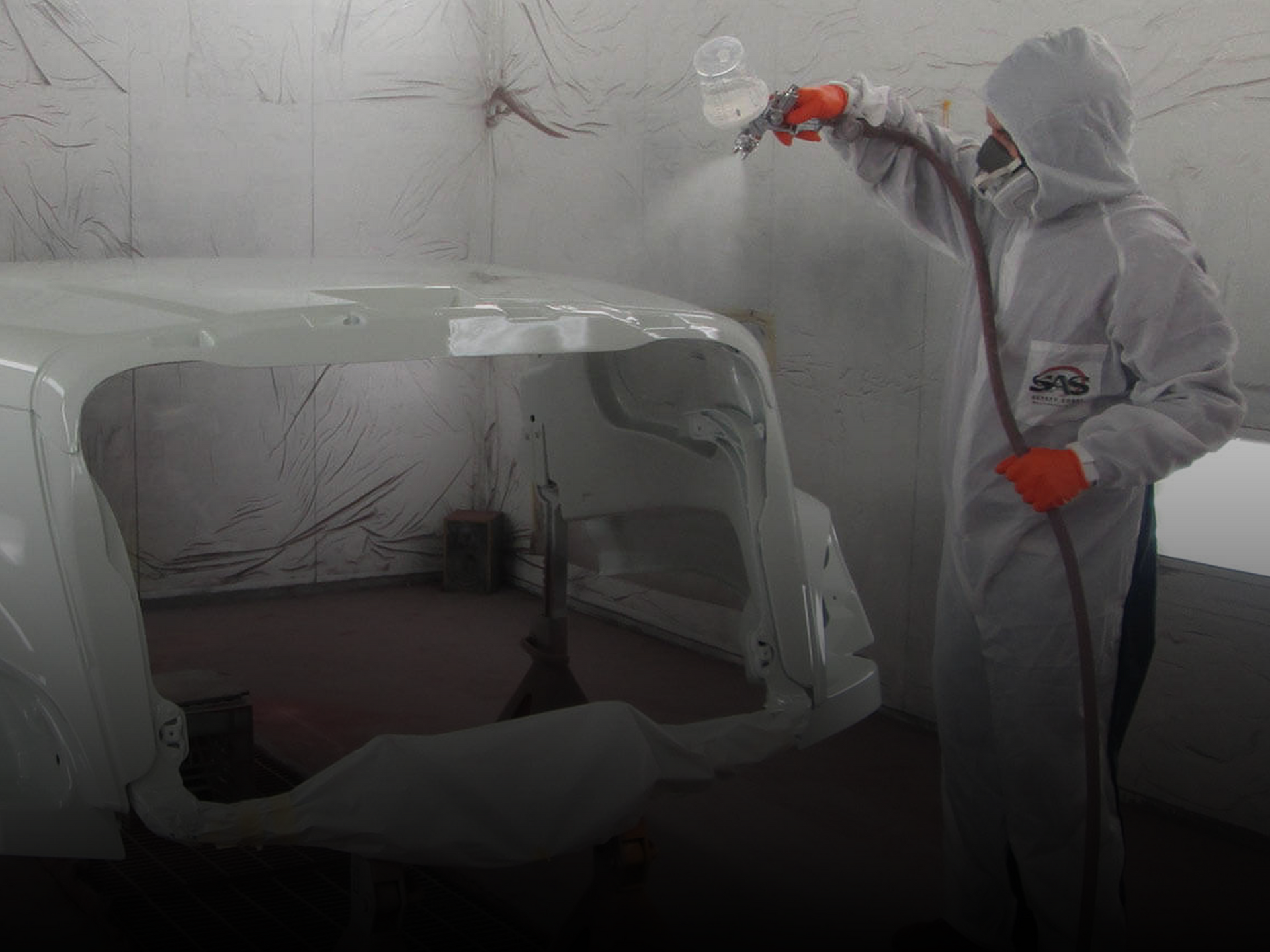 Technician applying fresh paint to vehicle inside B&G Auto Body spray booth
