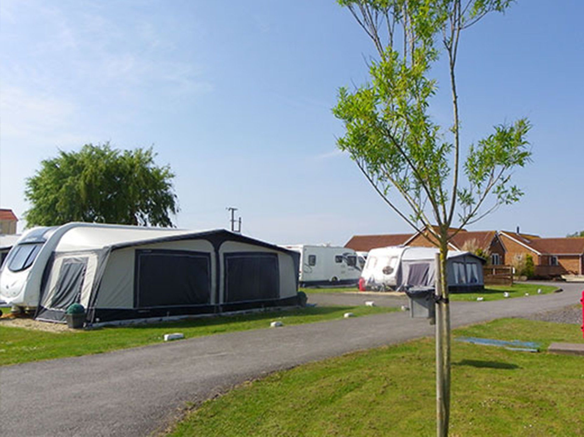 Caravan site with caravans with awnings attached in Somerset. - Rose Farm Holiday Park