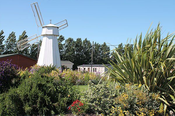 Entrance to Edithmead holiday park in Somerset with windmill and green areas.
