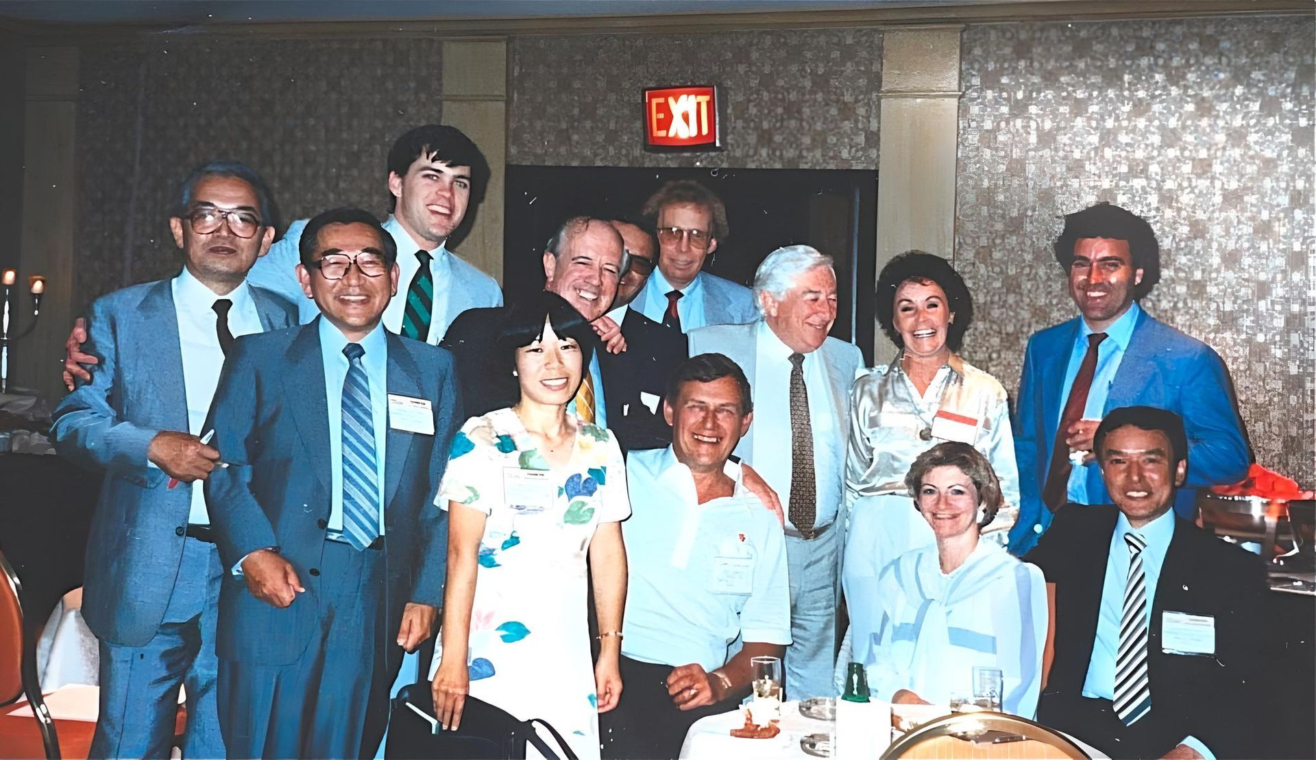 A group of people posing for a picture in front of an exit sign at J.F. Kelly Inc. company party