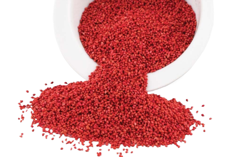 A bowl of red sprinkles is being poured into a pile