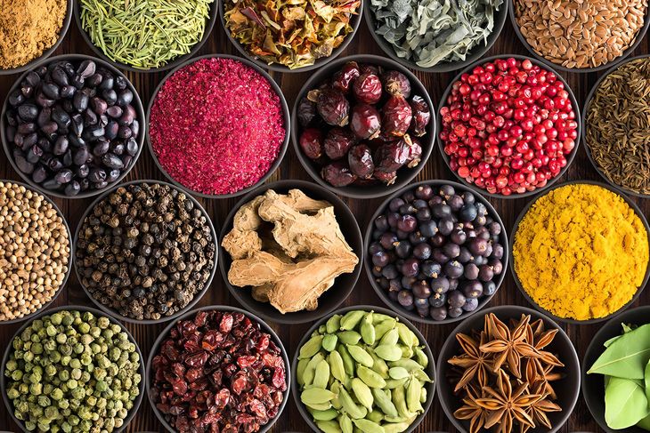 A variety of spices in bowls on a wooden table