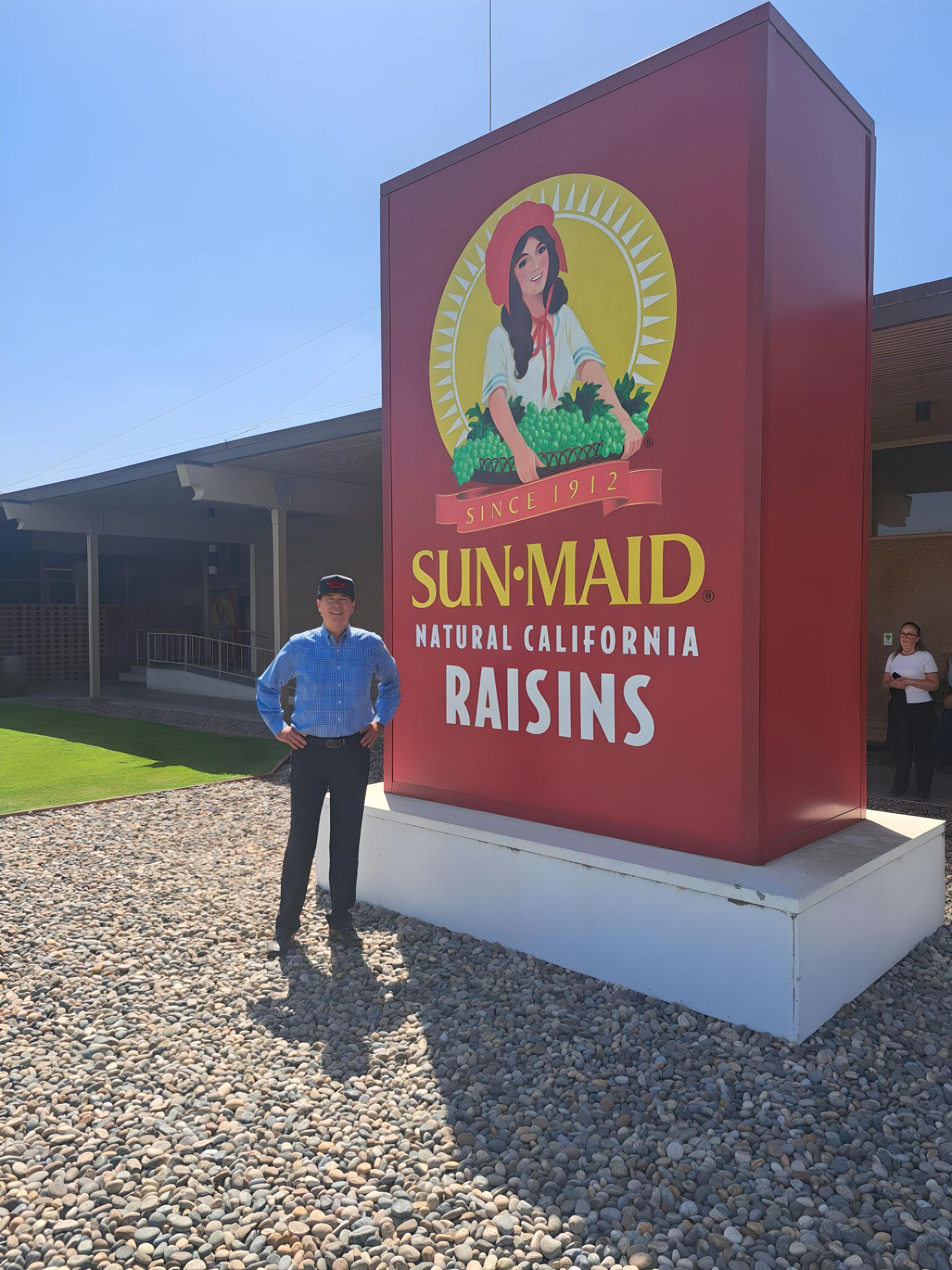 Michael Kelly standing in front of a large sign that says sun maid raisins in California