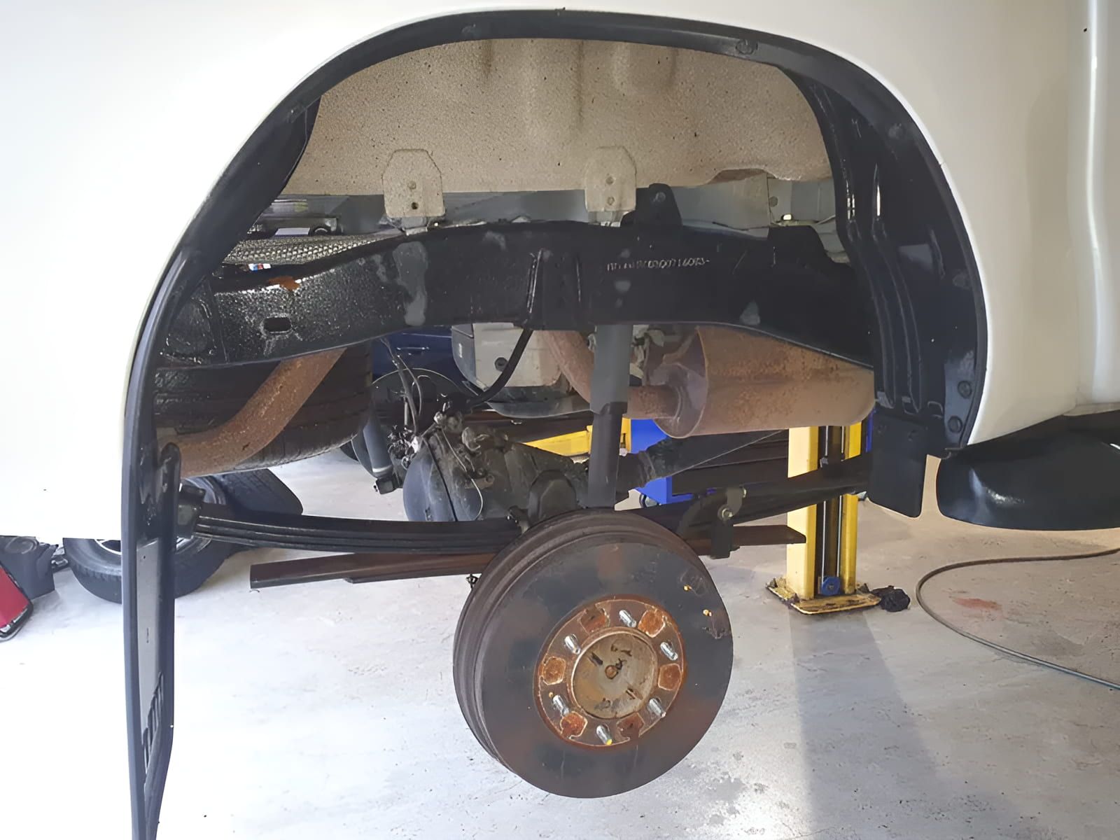 A White Truck is Sitting on a Lift in a Garage — GZM 4x4 Performance In Tweed Heads, NSW