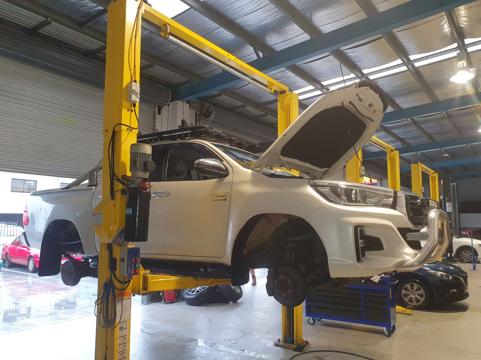 White Truck Raised on a Yellow Lift in a Repair Shop — GZM 4x4 Performance In Ballina, NSW
