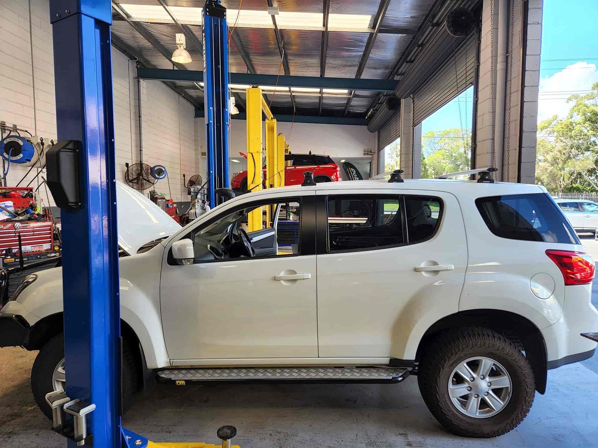 A White Suv is Parked on a Lift in a Garage — GZM 4x4 Performance In Gold Coast, NSW