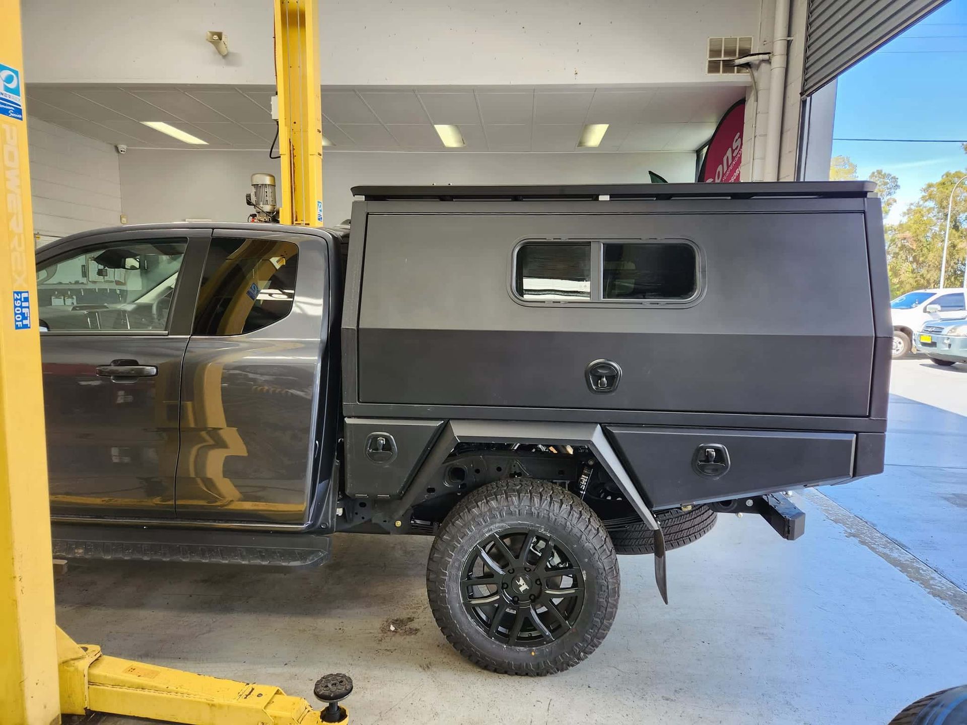 Dark Gray Pickup Truck With a Black Camper Shell in a Garage Setting — GZM 4x4 Performance In Ballina, NSW