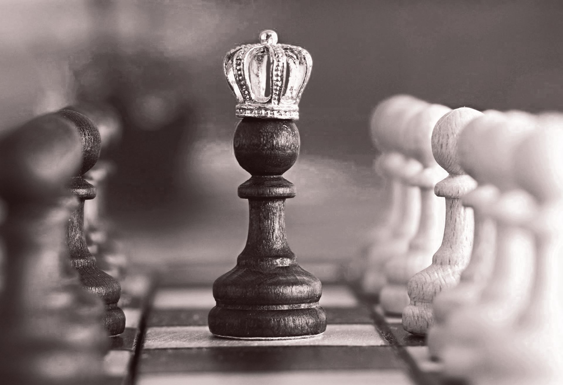 Een zwart-witfoto van een schaakbord met een koning met een kroon erbovenop.