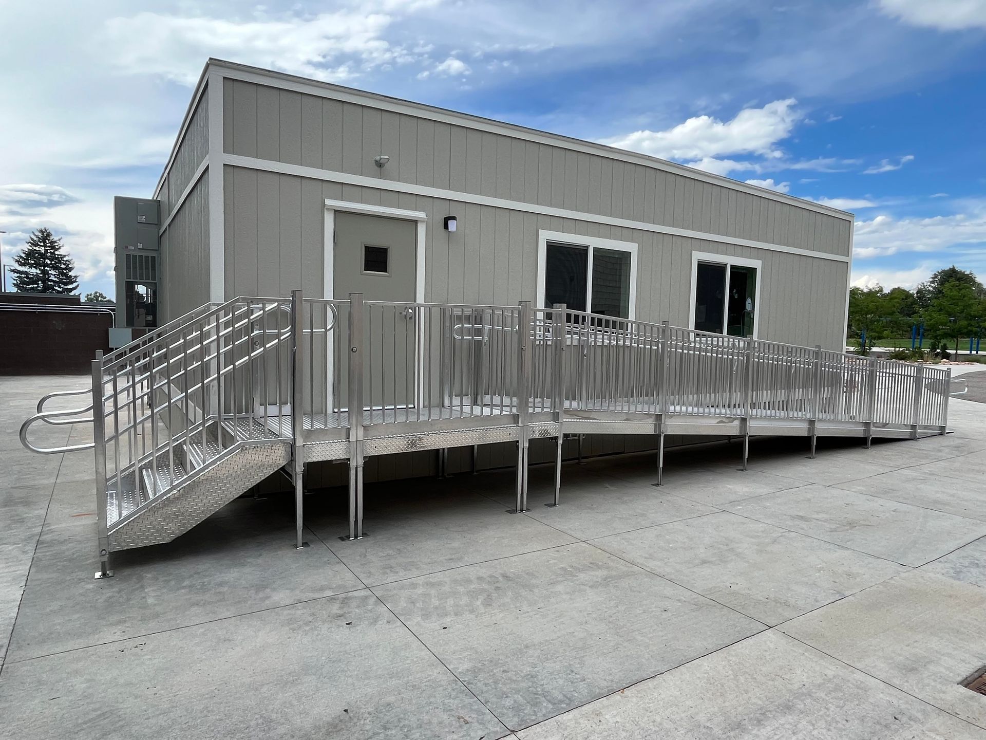 Gray modular building with a metal ramp for accessibility.