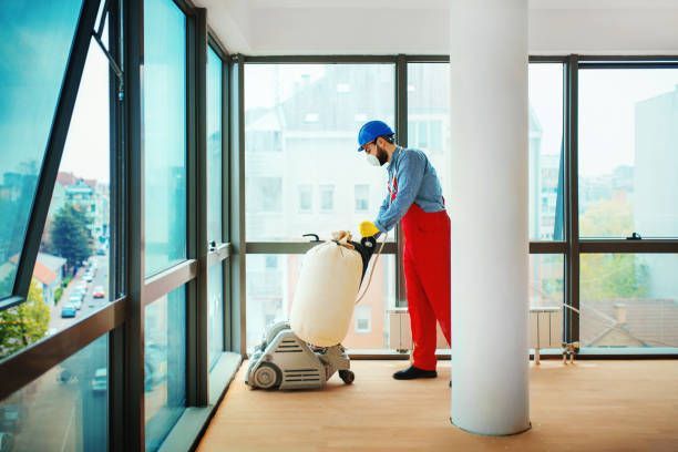 A person is sanding a wooden floor with a blue sander - Wivenhoe, TAS - Summers Floors Pty Ltd