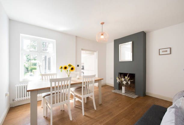 A dining room with a table and chairs and a fireplace - Wivenhoe, TAS - Summers Floors Pty Ltd
