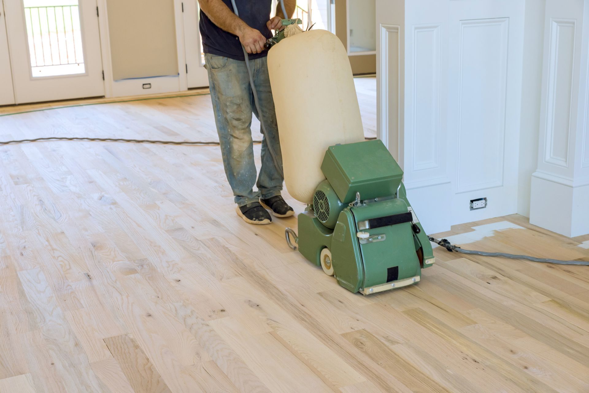 A man is sanding a wooden floor  - Wivenhoe, TAS - Summers Floors Pty Ltd