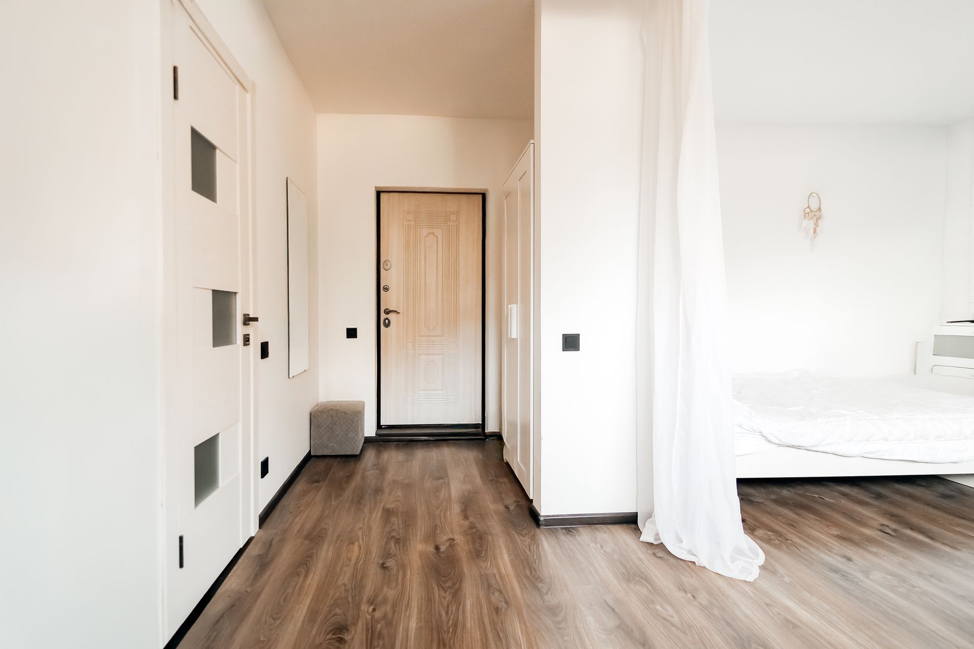 A hallway with hardwood floors and a bed in the background - Wivenhoe, TAS - Summers Floors Pty Ltd