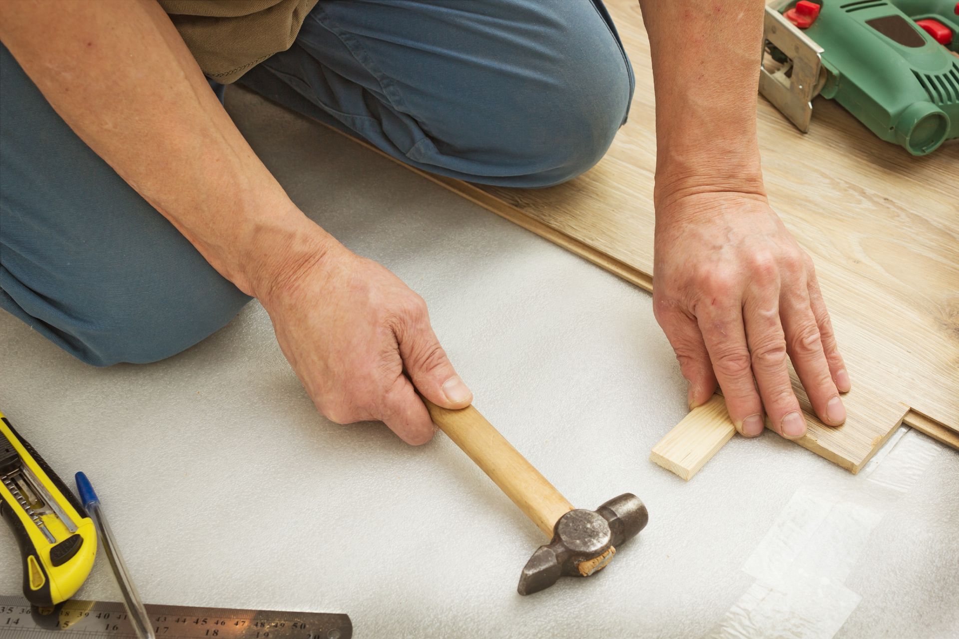 A man is using a hammer to hammer a piece of wood.
