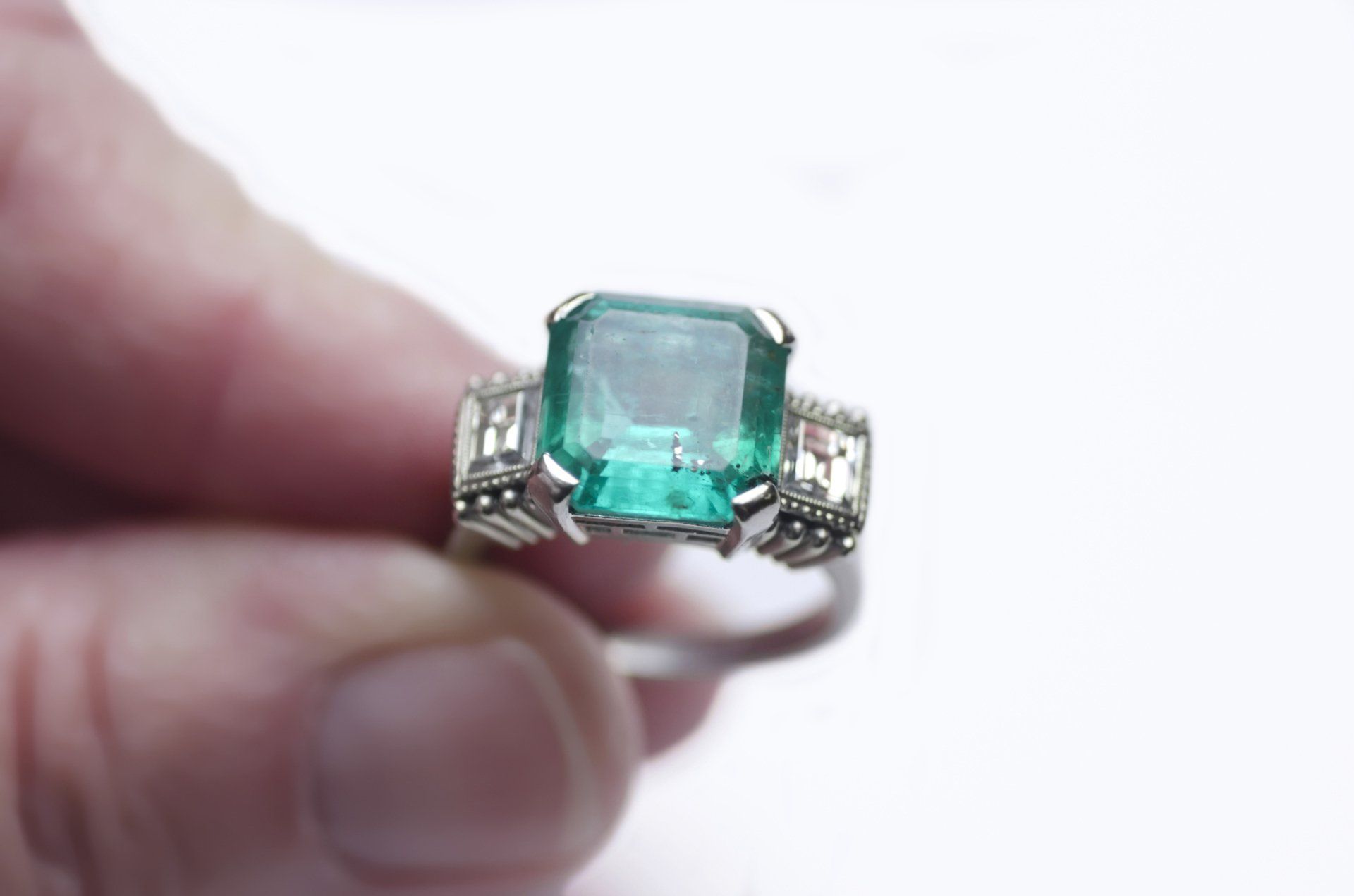 Woman Holds A Gold Ring With Emerald – Treasure Isle – Raleigh, NC
