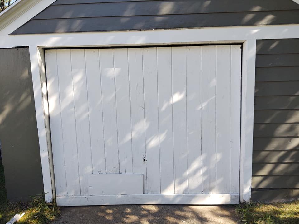 A white garage door with a gray roof