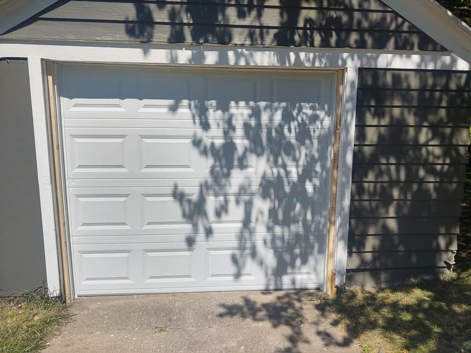 A white garage door with a tree shadow on it
