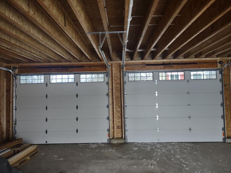 Two garage doors are open in a garage under construction