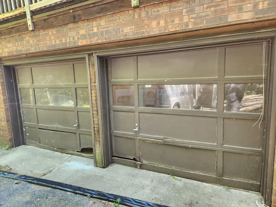 A garage door with a broken window is sitting on the side of a brick building.
