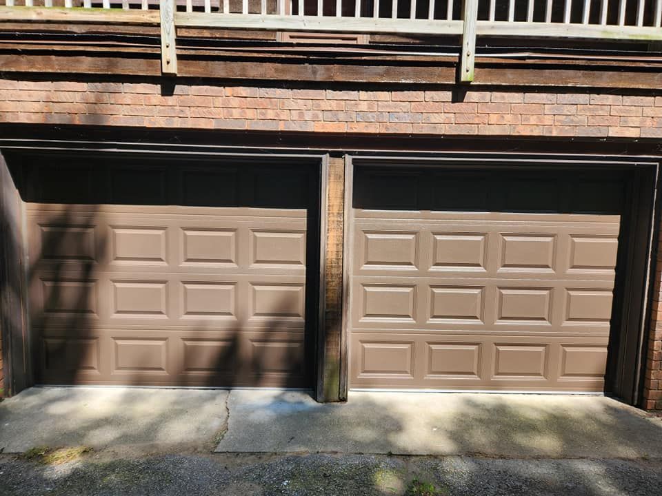 A pair of brown garage doors on a brick building