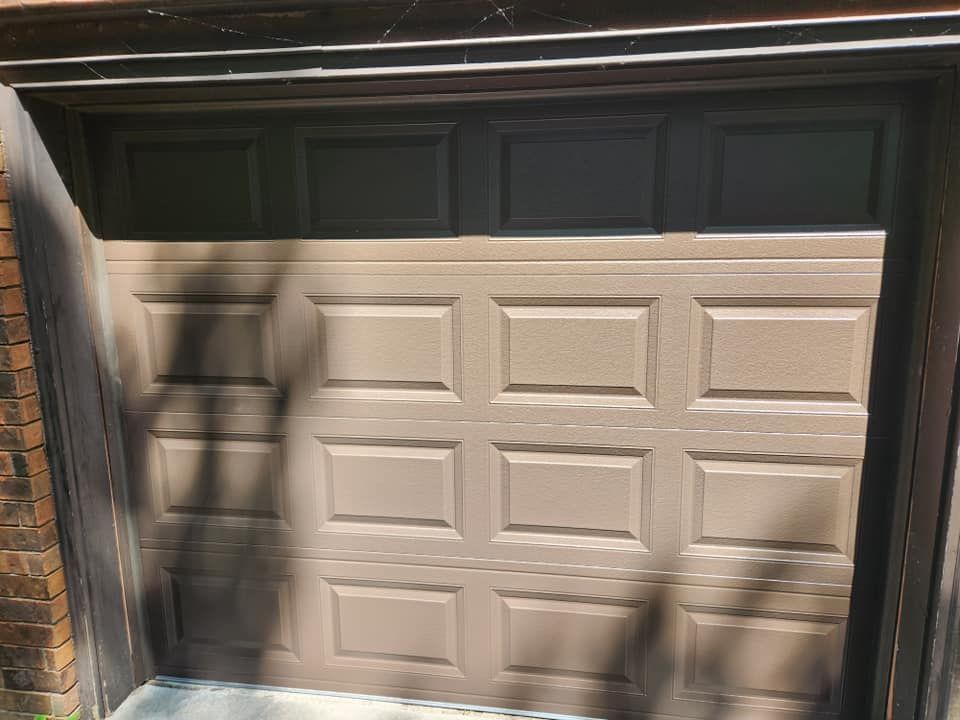 A brown garage door with a black trim is open