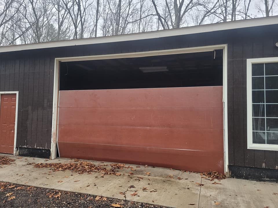 A brown garage door is open on a house with a window.