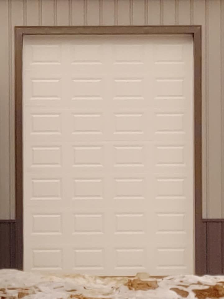 A white garage door is sitting on top of a pile of snow.