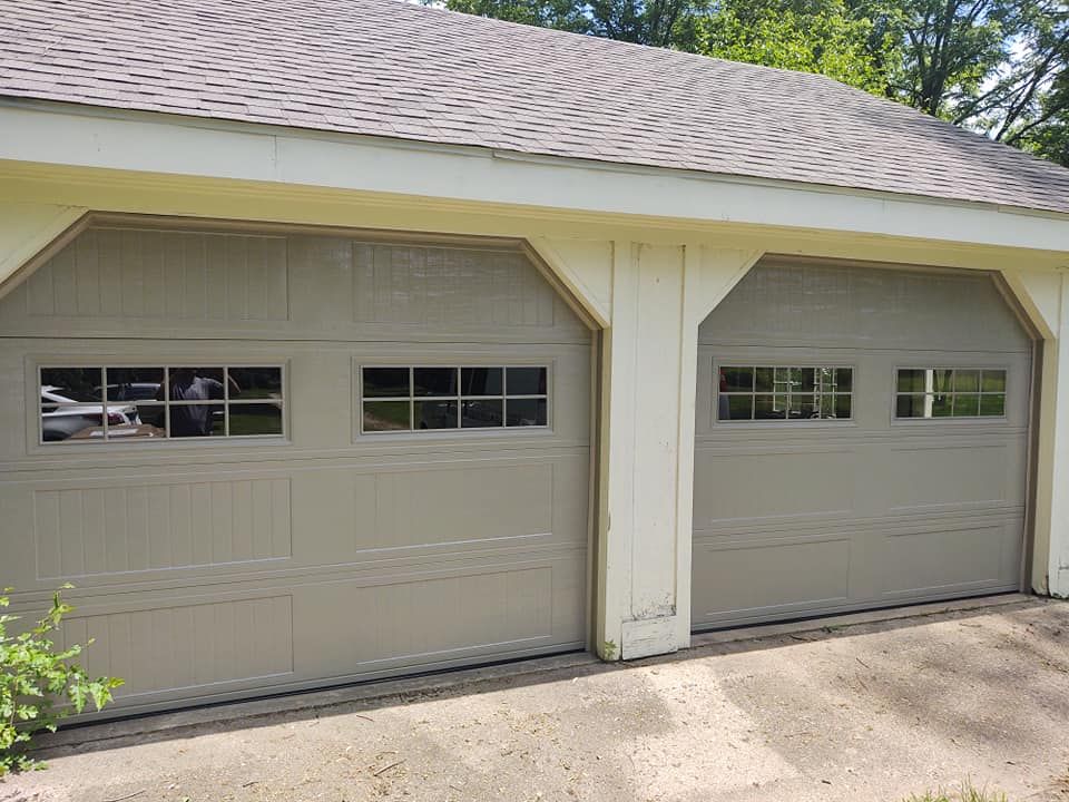 A garage with two garage doors and a roof.