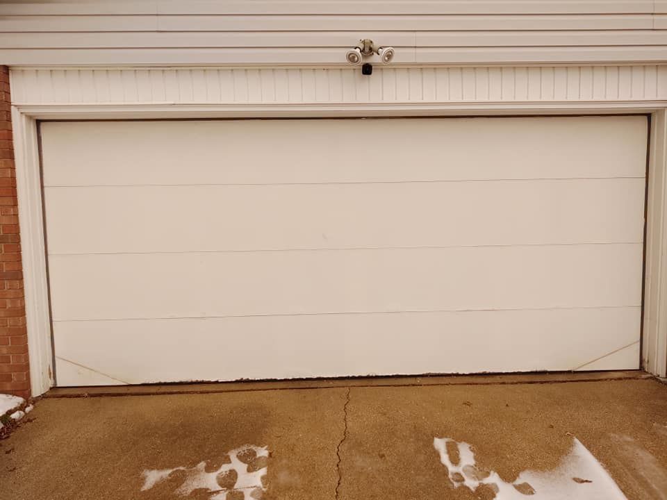 A white garage door with a camera on top of it