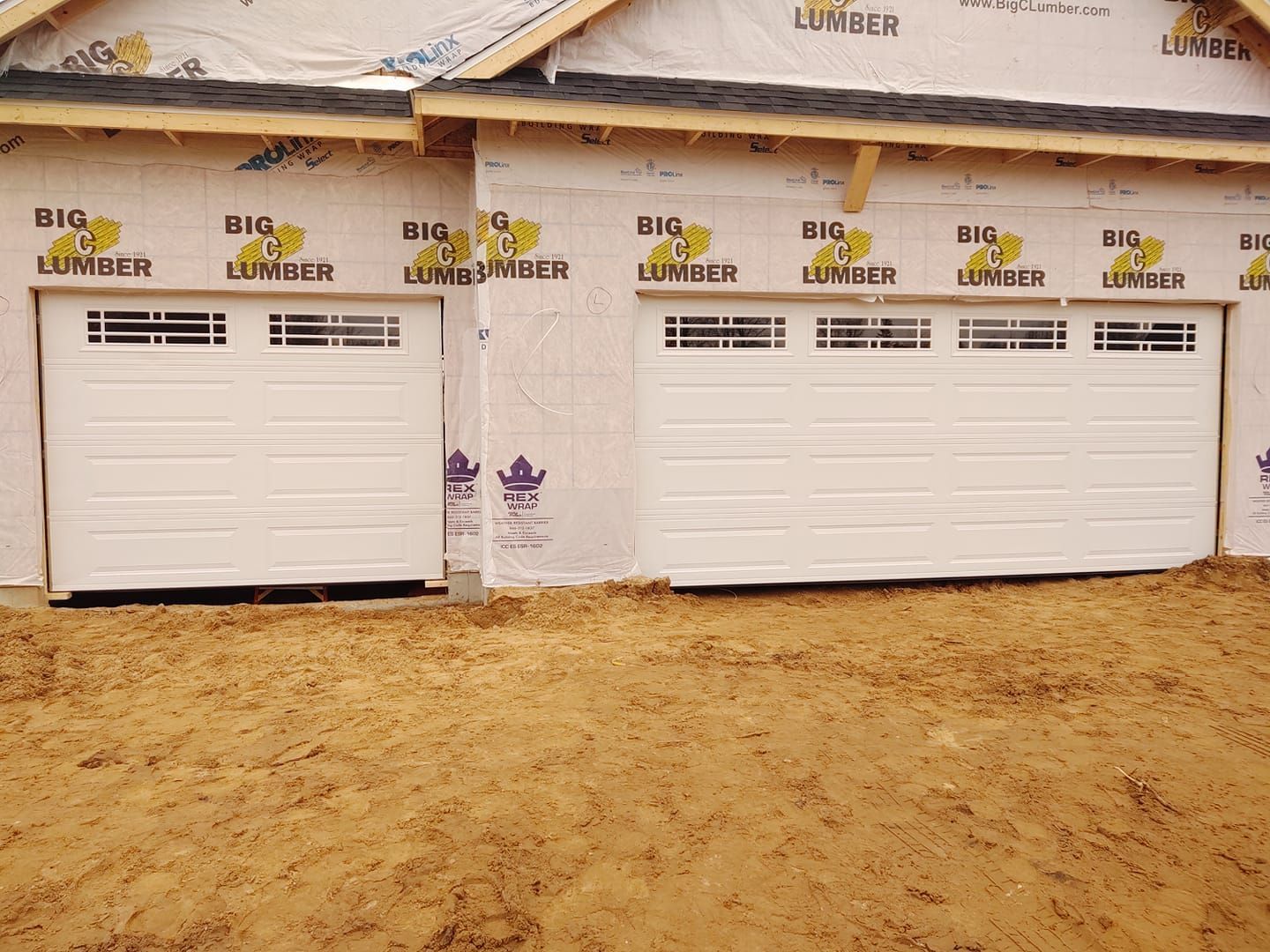 A house under construction with a garage door that says big lumber
