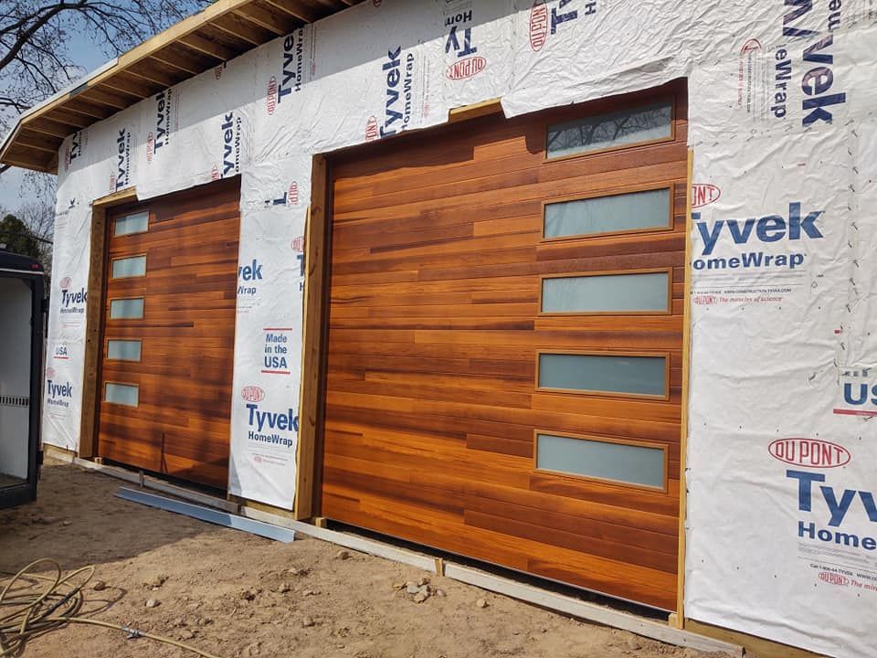 A wooden garage door is being installed on a building.