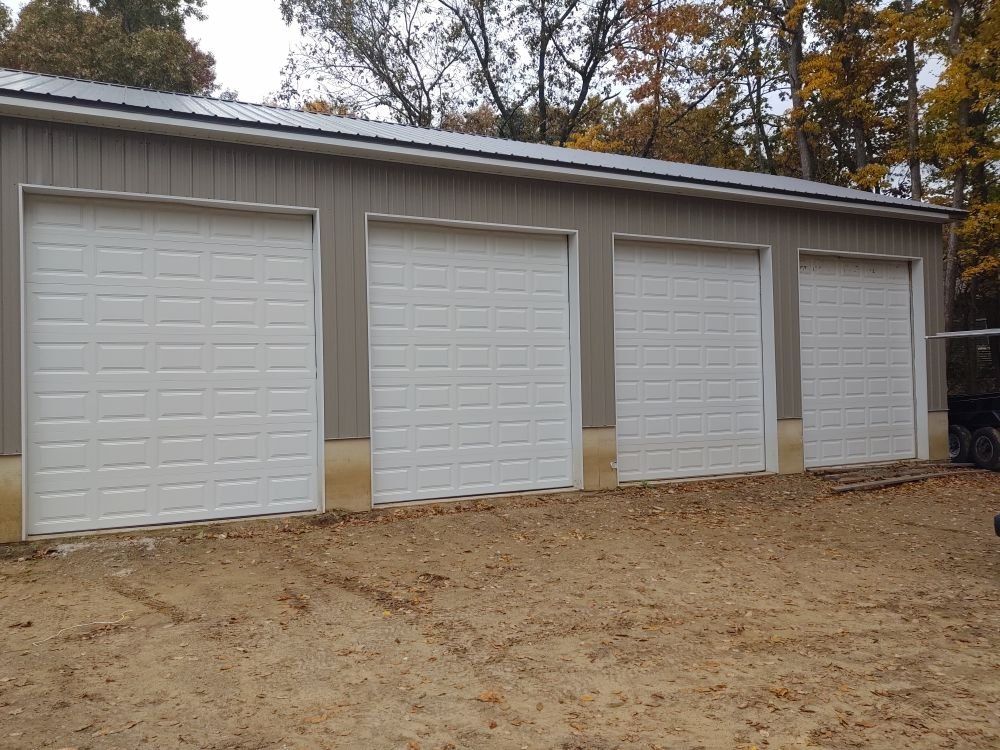 A row of white garage doors are lined up in a row.