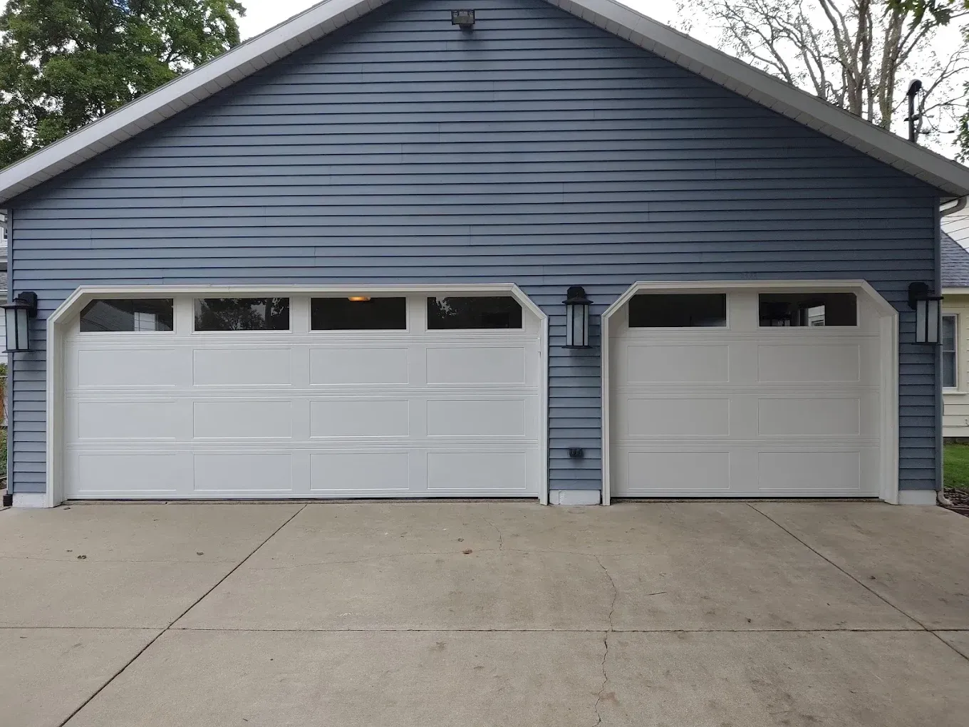 A blue house with two white garage doors