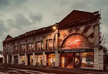 Exterior of the Curzon Cinema & Arts in a historic building with arched entrance and illuminated sign.