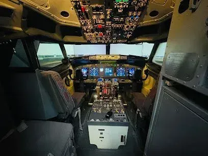 Cockpit interior of a commercial airplane, showing instrument panels, seats, and a simulated runway view.
